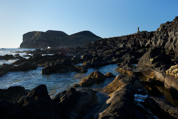View of Capelinhos volcano and ruined lighthouse from the rocky coastline
